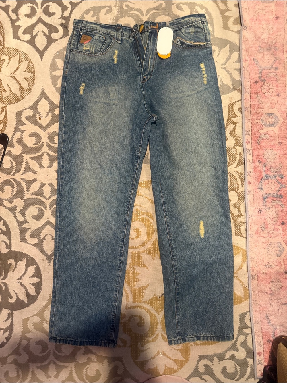 Akademiks Orange and Gray Brand Hang Tag on Denim